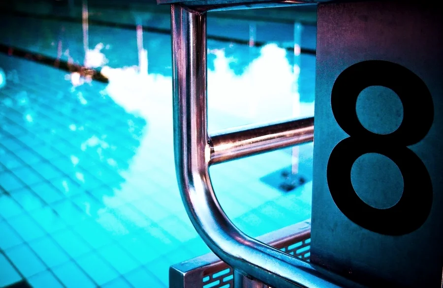 A pool ladder beside a lane number